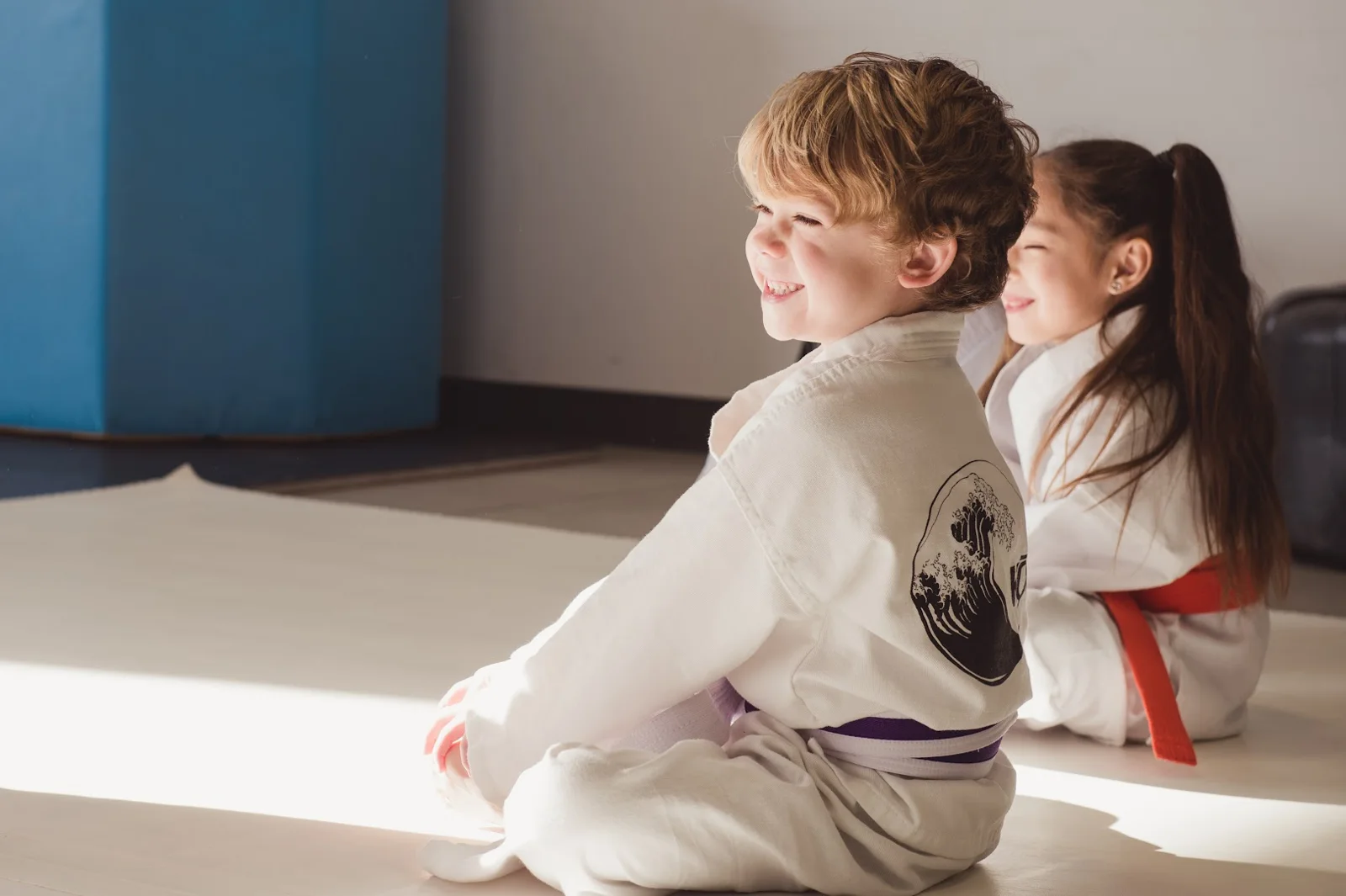A happy kids karate student with an instructor at Kona Karate