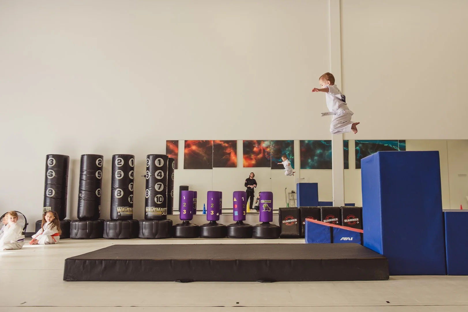 The wide, open training floor at Kona Karate in Centerville, with heavy bags and a padded jump area along the wall